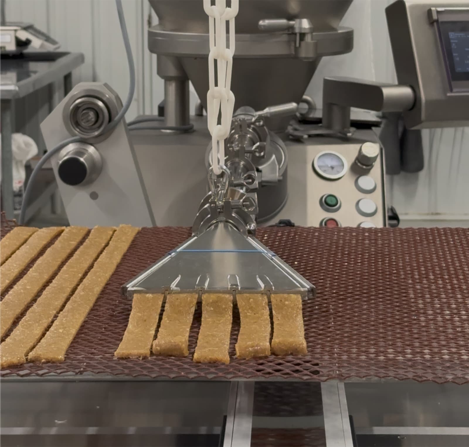 The Meat Bot multi-channel nozzle depositing five uniform strips onto a tray