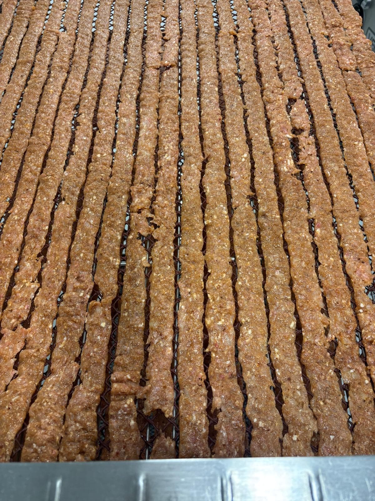 Jerky strips formed by hand — uneven thickness and rough edges